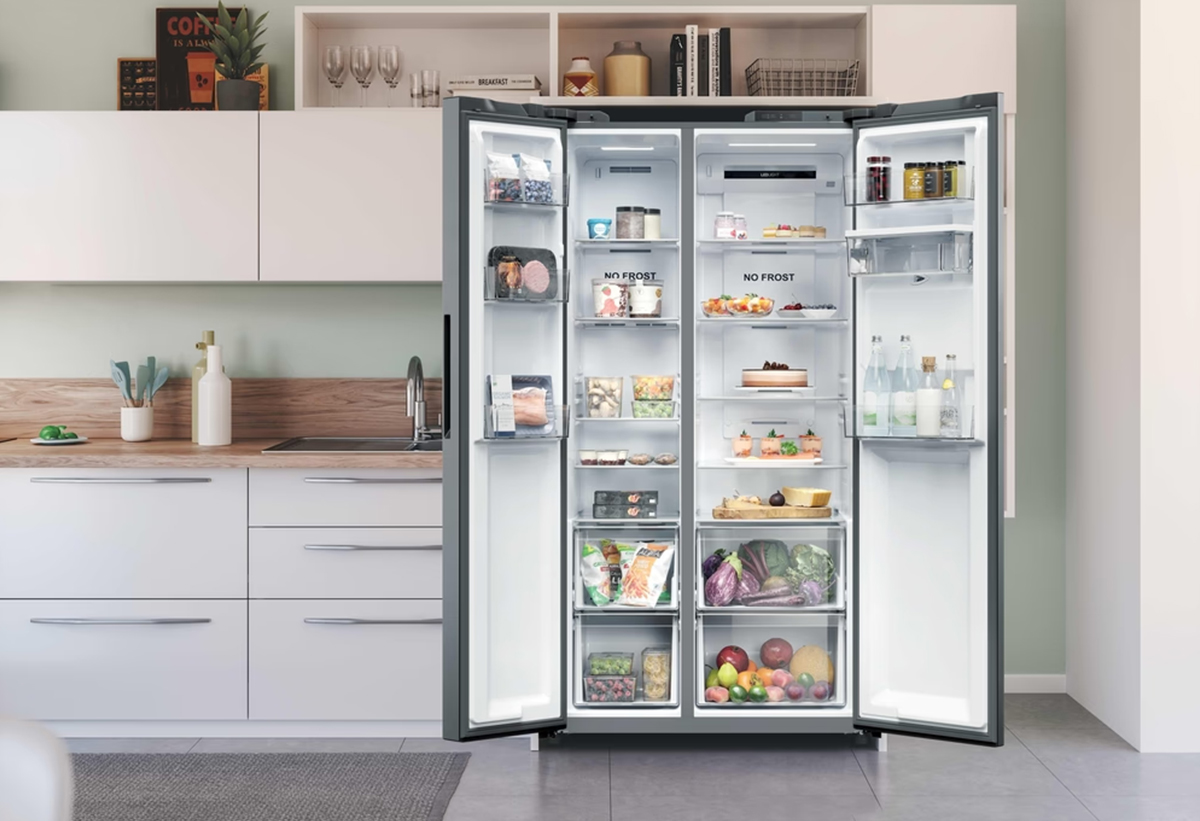 Απεικονίζεται το ψυγείο ανοιχτό σε κουζίνα.